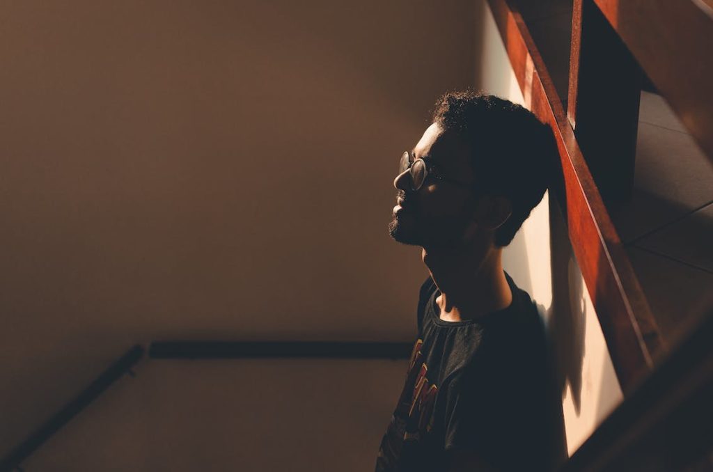 A lonely man leaning on the wall