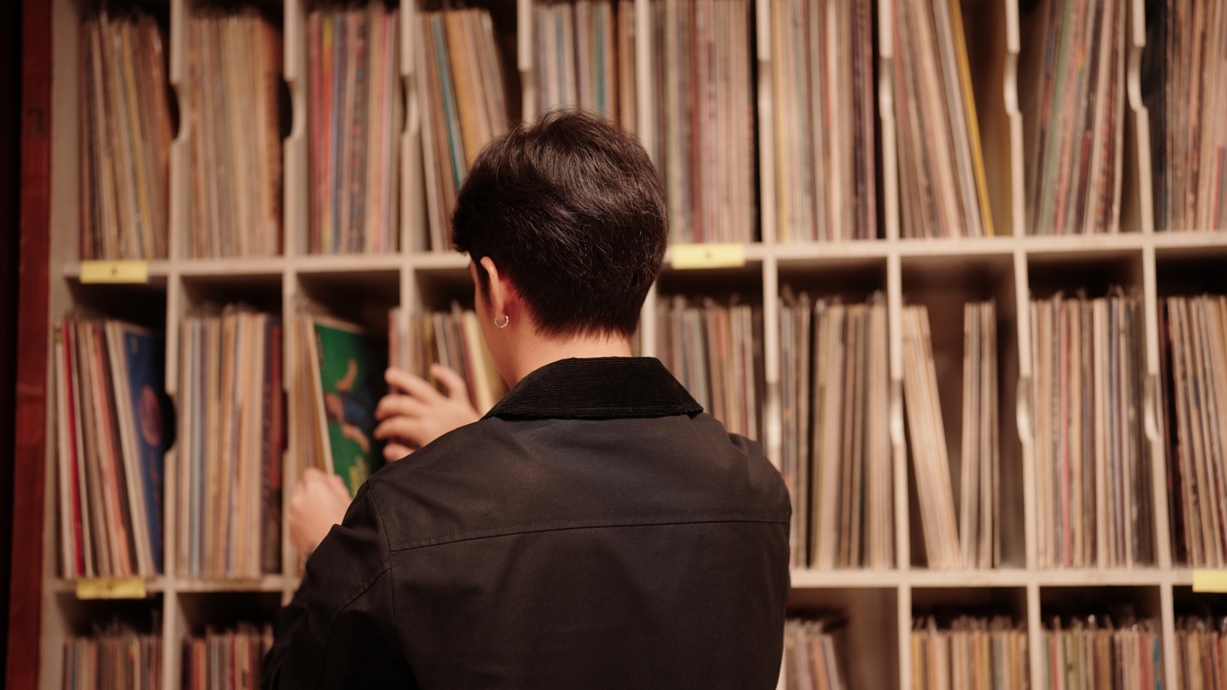 a man looking at vinyls at the record shop