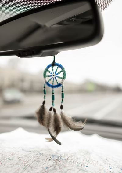 a cute dream catcher hanging on the car mirror