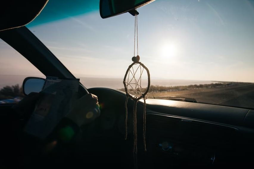 a dream catcher hanging on the car mirror