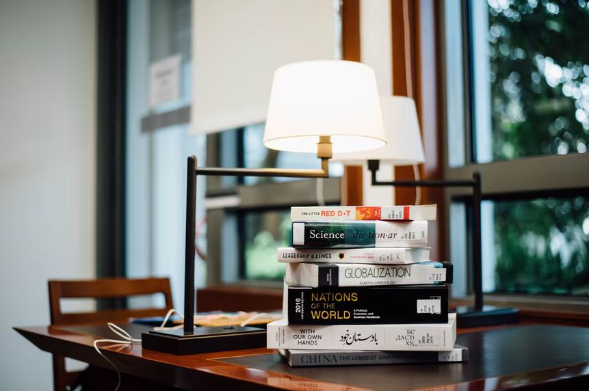 a lamp beside a stack of books