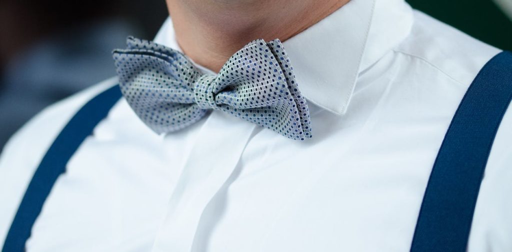 A close-up image of a man wearing a polka dotted bow tie