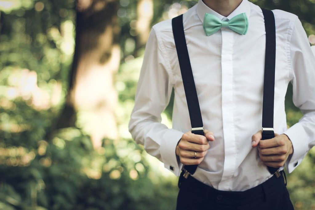 A person wearing black suspender along with a bow tie