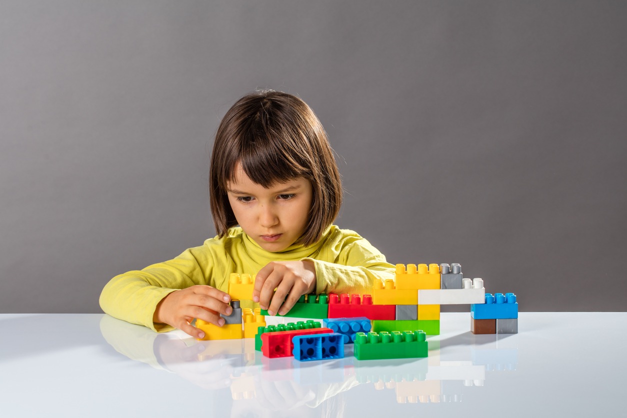 A kid thinking about organizing toys with engineer imagination