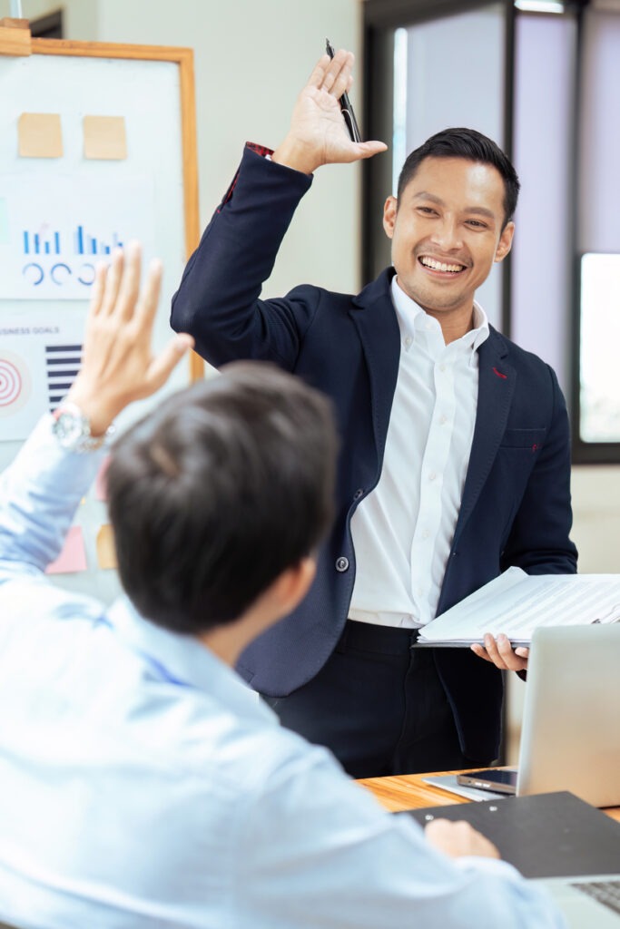 Businesspeople smile and high five , feeling celebrate after project or agreement success with colleague