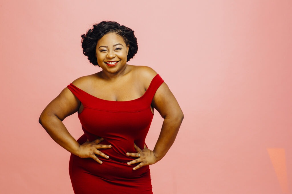 Portrait of a happy and confident plus size model in red dress