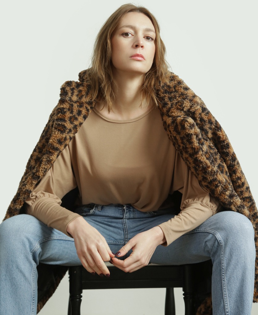 Woman wearing matching beige shirt and leopard teddy coat